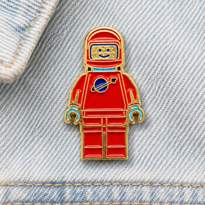 Red and blue astronaut enamel pin badge with gold frame and helmet face