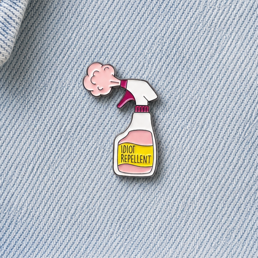 Enamel pin badge on light blue denim, showing pink cloud spraying a bottle design