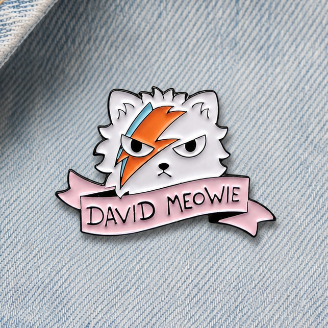 Enamel cat lightning-bolt pin badge on light blue denim, white cat with orange accents