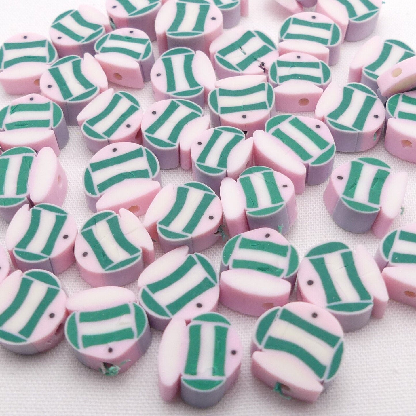 Pink and grey polymer clay beads with green-and-white striped design, teardrop shapes