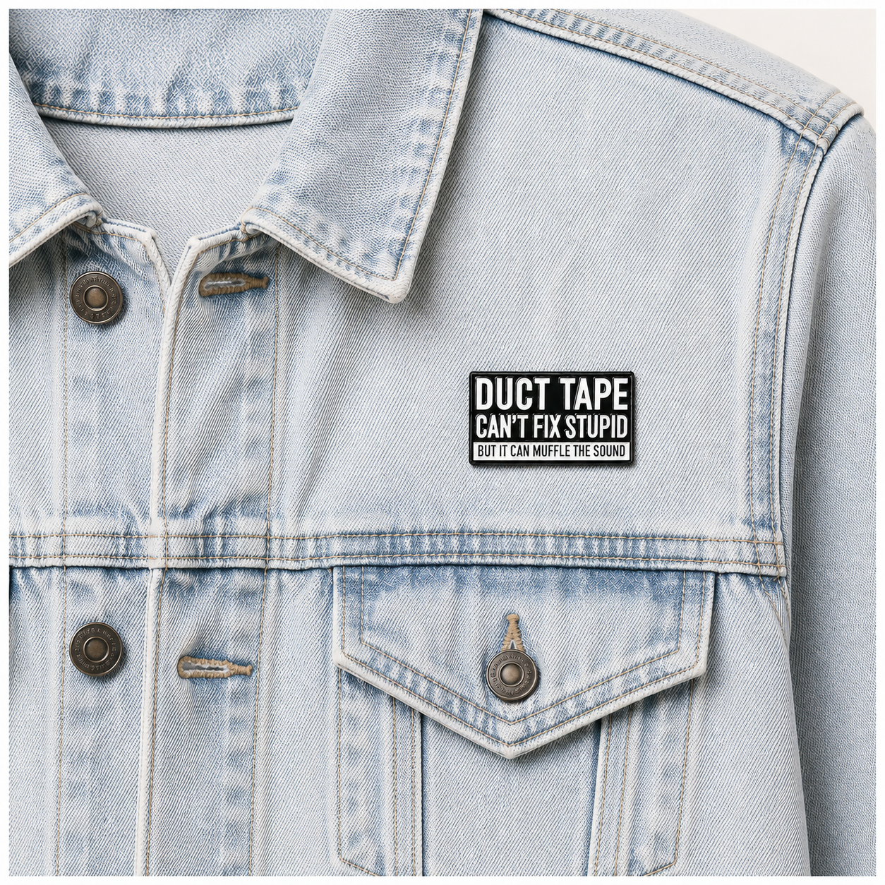 Enamel pin badge on light blue denim jacket chest near pocket