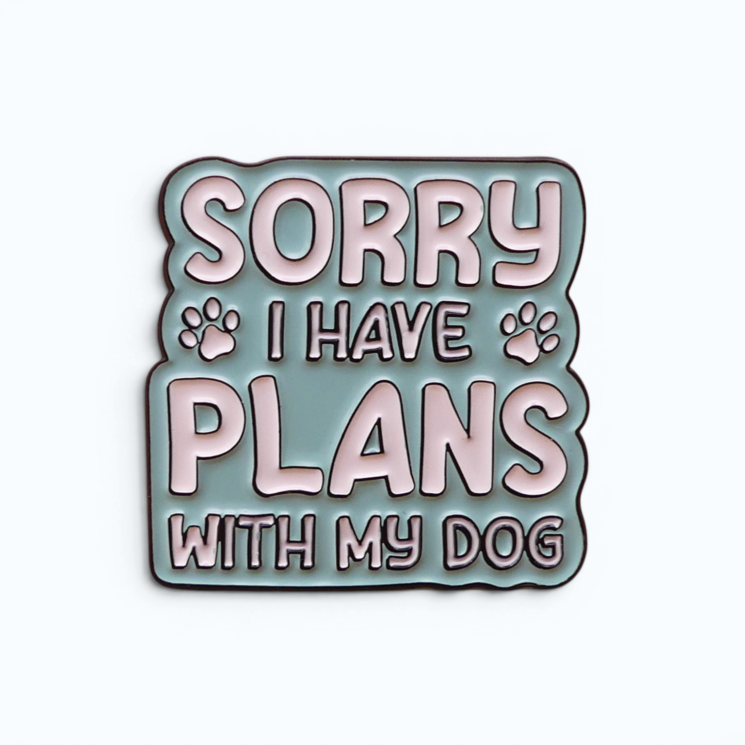 A square enamel pin with a wavy border featuring the text 'SORRY I HAVE PLANS WITH MY DOG' in white letters on a muted blue background, with small paw prints on either side.