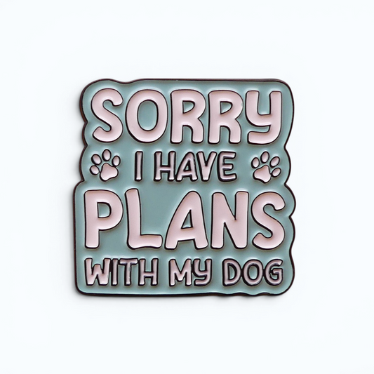 Enamel pin badge showing 'SORRY I HAVE PLANS WITH MY DOG' in pink and mint