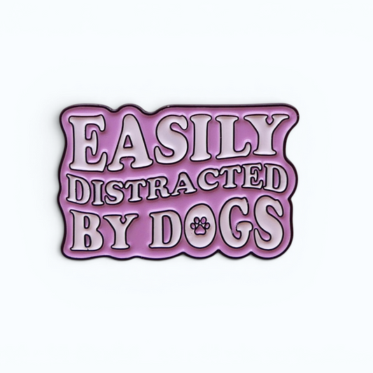 Purple enamel pin badge reading Easily Distracted by Dogs