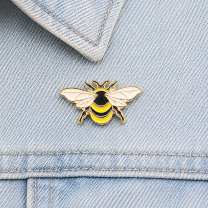 Bumblebee enamel pin on light blue jeans waistband with stitched seams