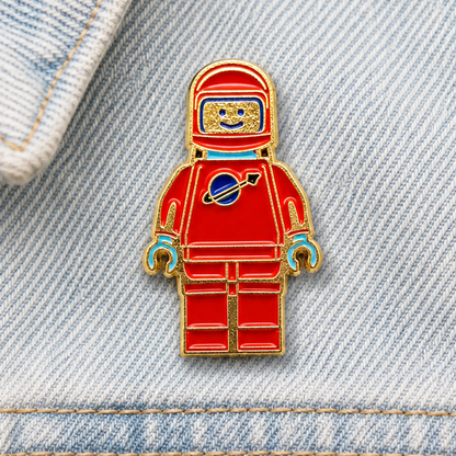 Red and blue astronaut enamel pin badge with gold frame and helmet face