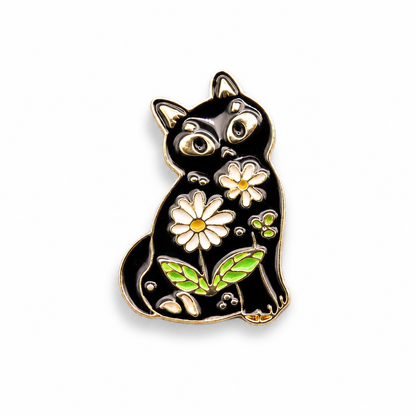 Black cat enamel pin with gold outline, daisy flowers, green leaves, and colorful details.
