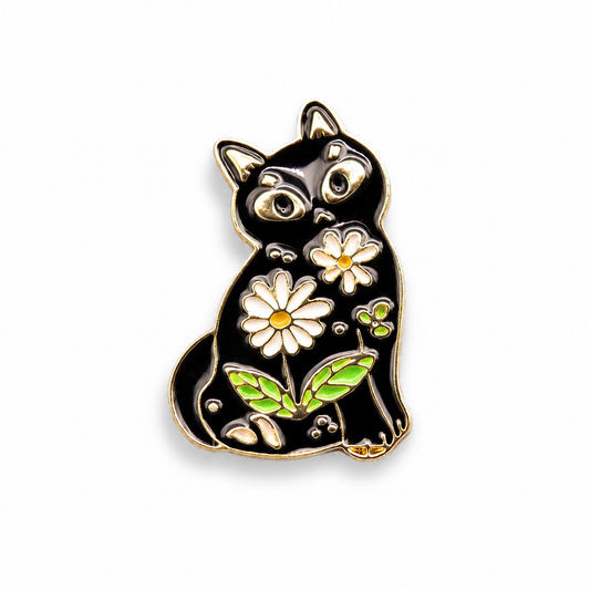 Black cat enamel pin with gold outline, daisy flowers, green leaves, and colorful details.