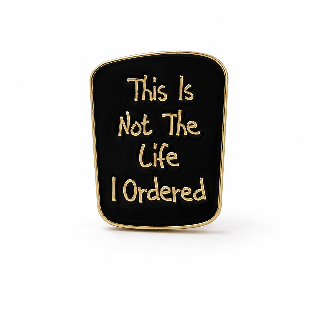 Gold-rim enamel pin badge with black quote: “This Is Not The Life I Ordered”