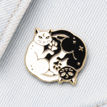 White and black yin-yang cat enamel pin badge with gold outline and paw prints