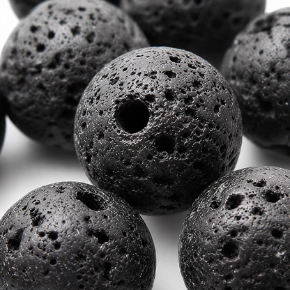 Close-up of black round lava stone beads with rough texture and drilled holes