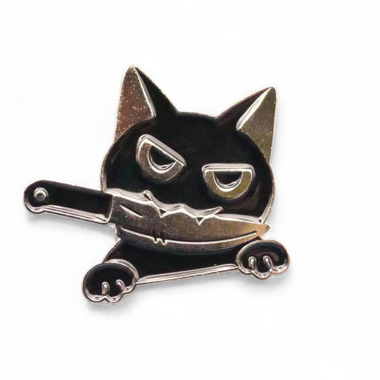 Black and silver cat-shaped enamel pin with knife between its teeth 