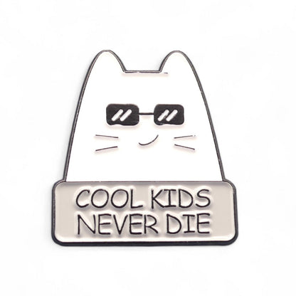 white cat in black glasses with text cool kids never die enamel in badge.