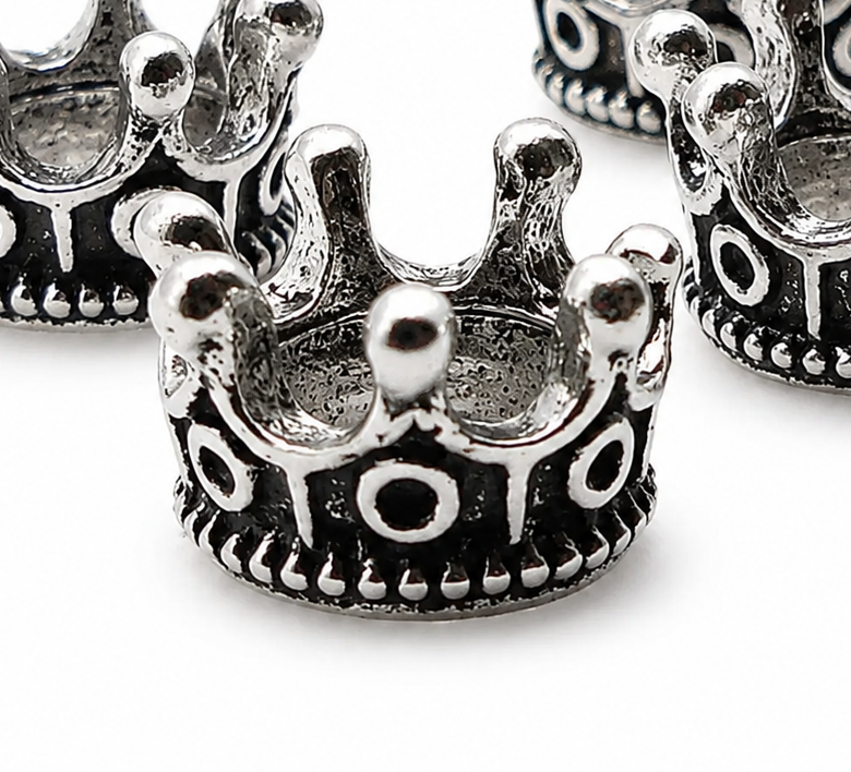 Close-up of antique silver crown spacer bead with round studs and oval cutout pattern