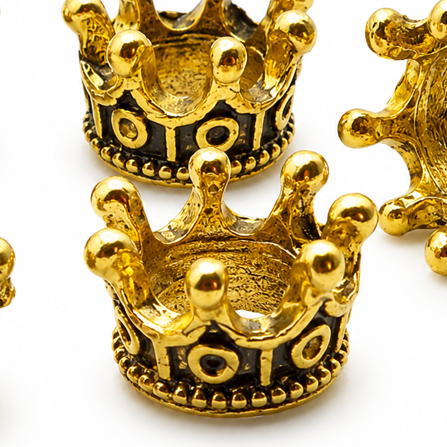 Close-up gold tone crown spacer bead with dark enamel eyes and decorative dots
