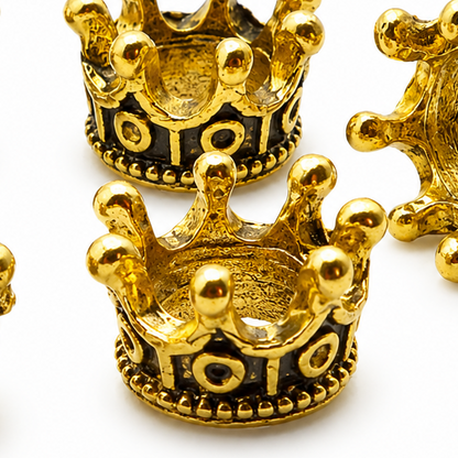 Close-up gold tone crown spacer bead with dark enamel eyes and decorative dots
