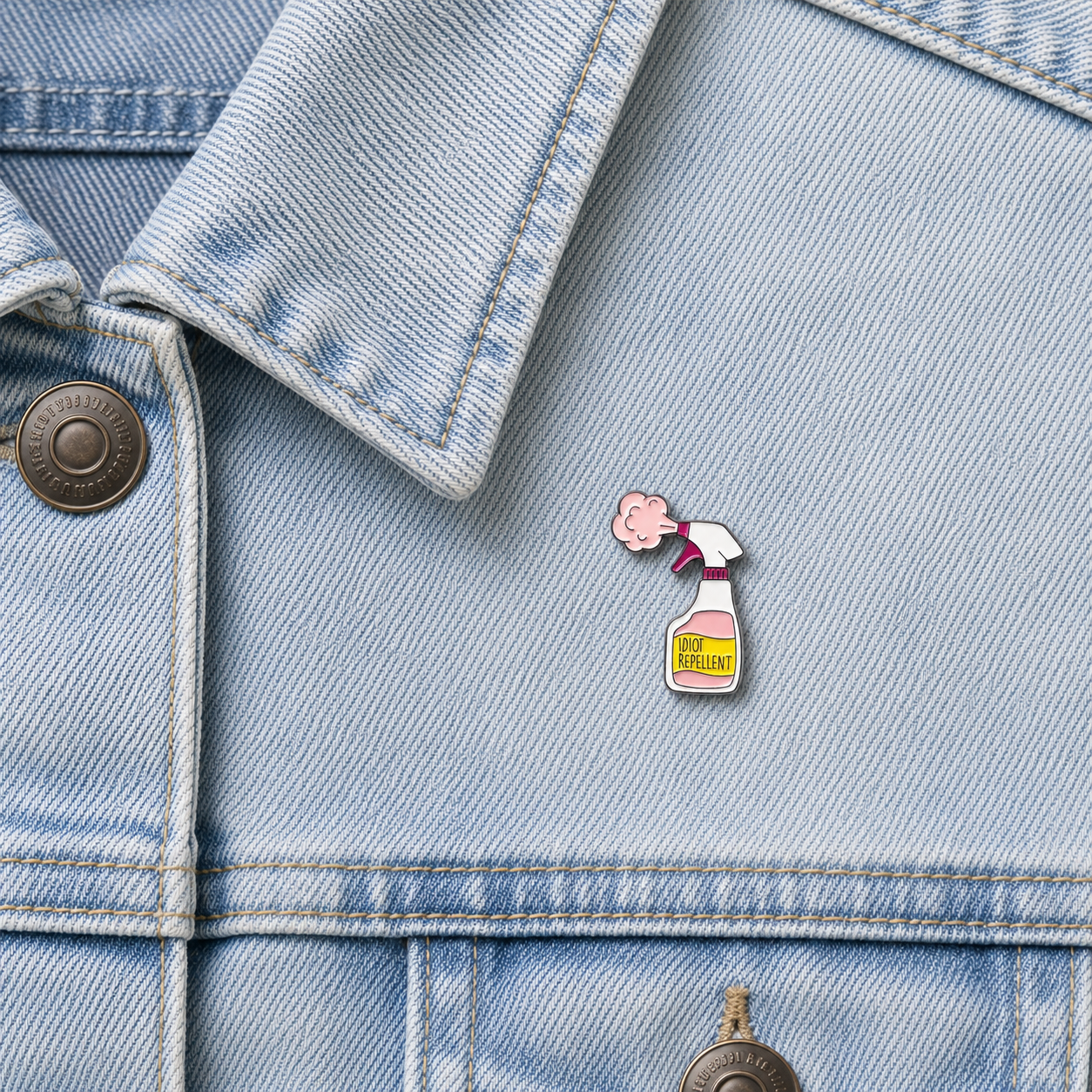 Enamel pin badge featuring a spray bottle and pink cloud face on light blue denim