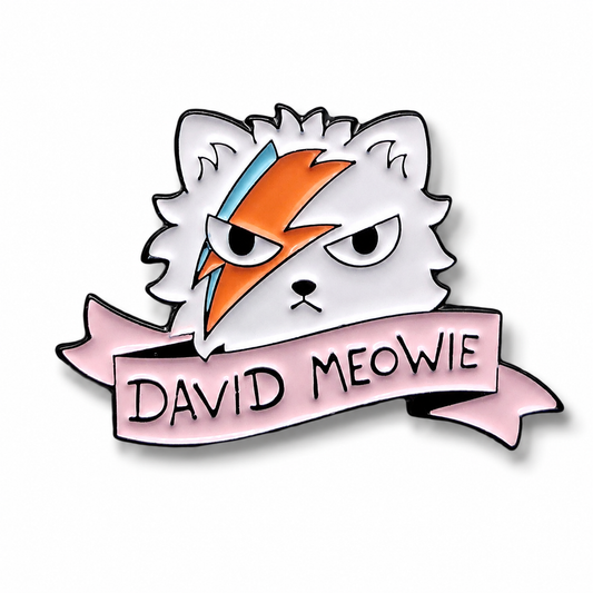 A cartoon-style enamel pin or sticker featuring a white cat head with an orange and blue lightning-bolt face design, above a pink banner that reads “DAVID MEOWIE,” on a plain white background.