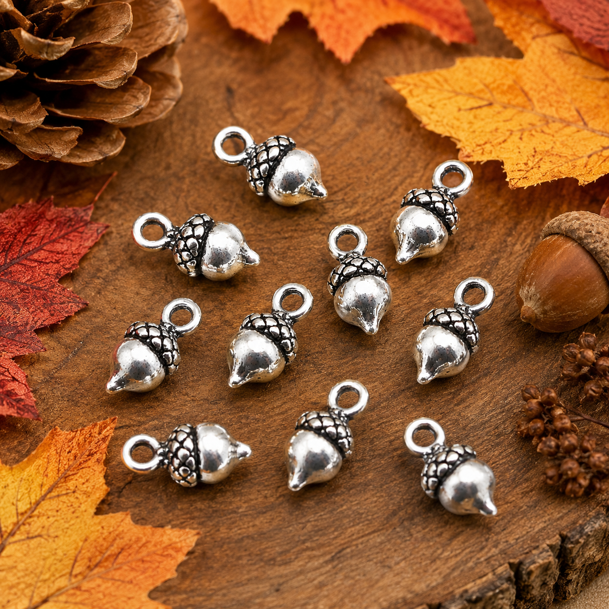 Tibetan silver 3D acorn charms scattered on autumn leaves, each with hanging loop