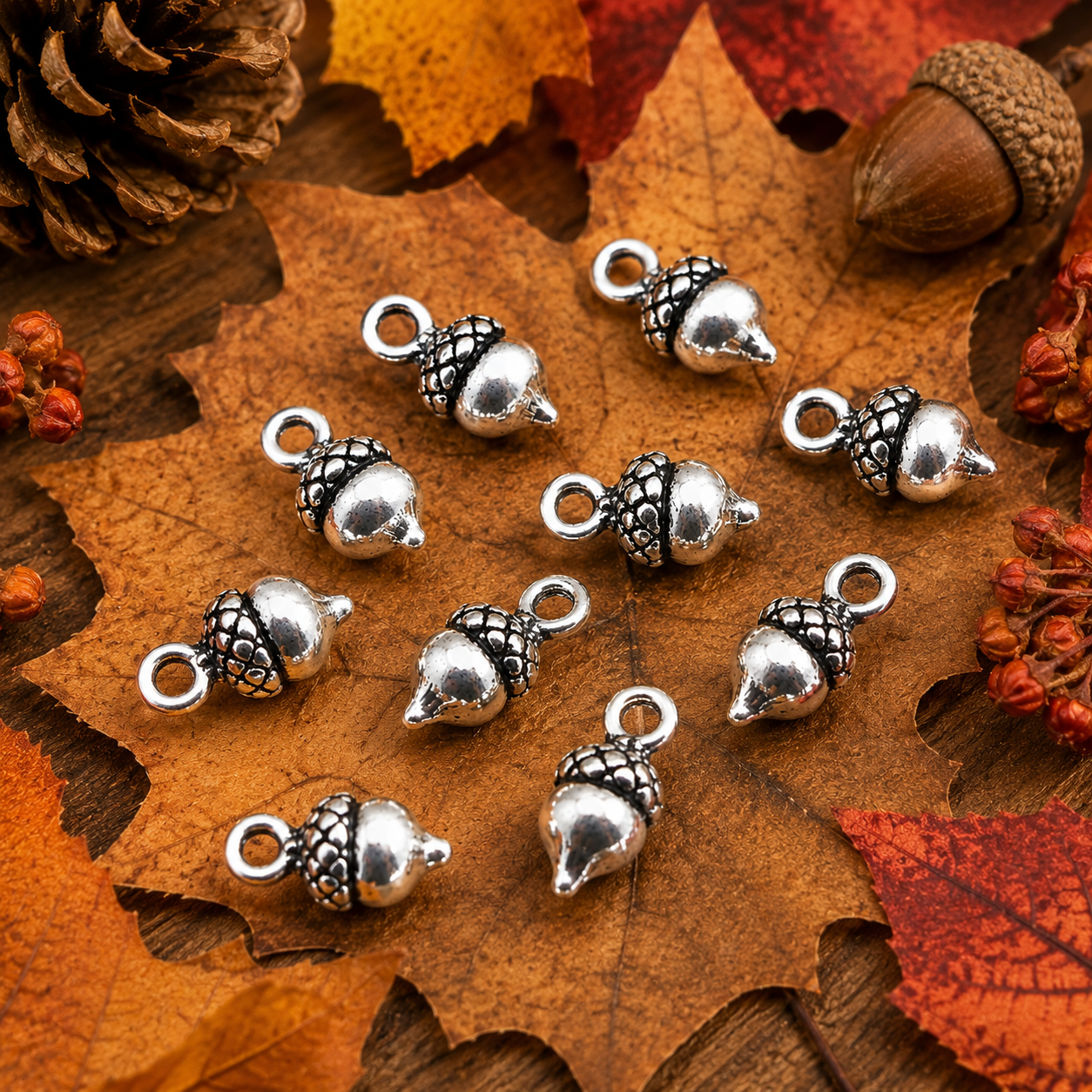 Tibetan silver acorn charms on fall leaves, glossy metal pendants with ring loop