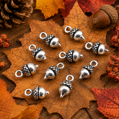 Tibetan silver acorn charms on fall leaves, glossy metal pendants with ring loop
