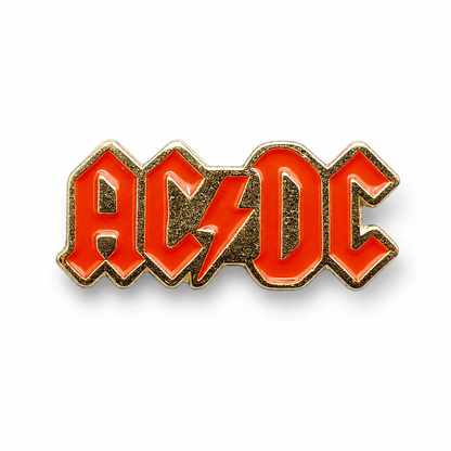 AC/DC enamel pin badge with red letters and gold outline, metal backing pin stem