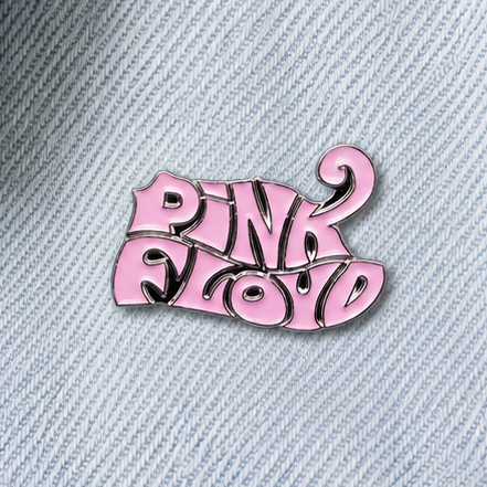 Pink enamel logo pin badge on light blue denim with glossy black detailing