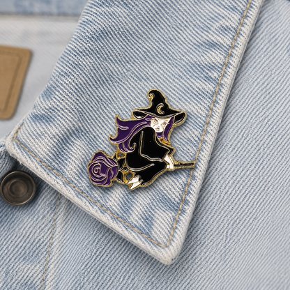 Witch on broom enamel pin with purple rose on light blue denim pocket