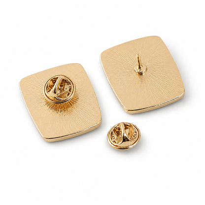 Enamel pin badge, gold-tone square back with metal clasp posts and circular pin backing.