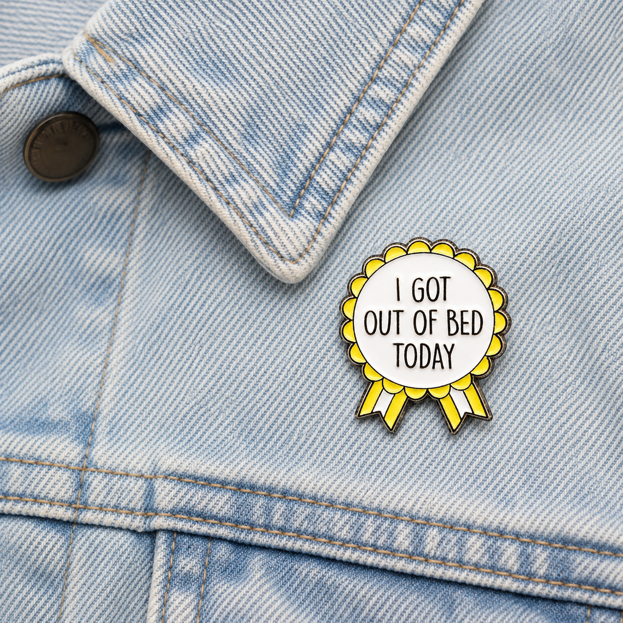 Yellow and white rosette enamel pin on light blue denim jacket