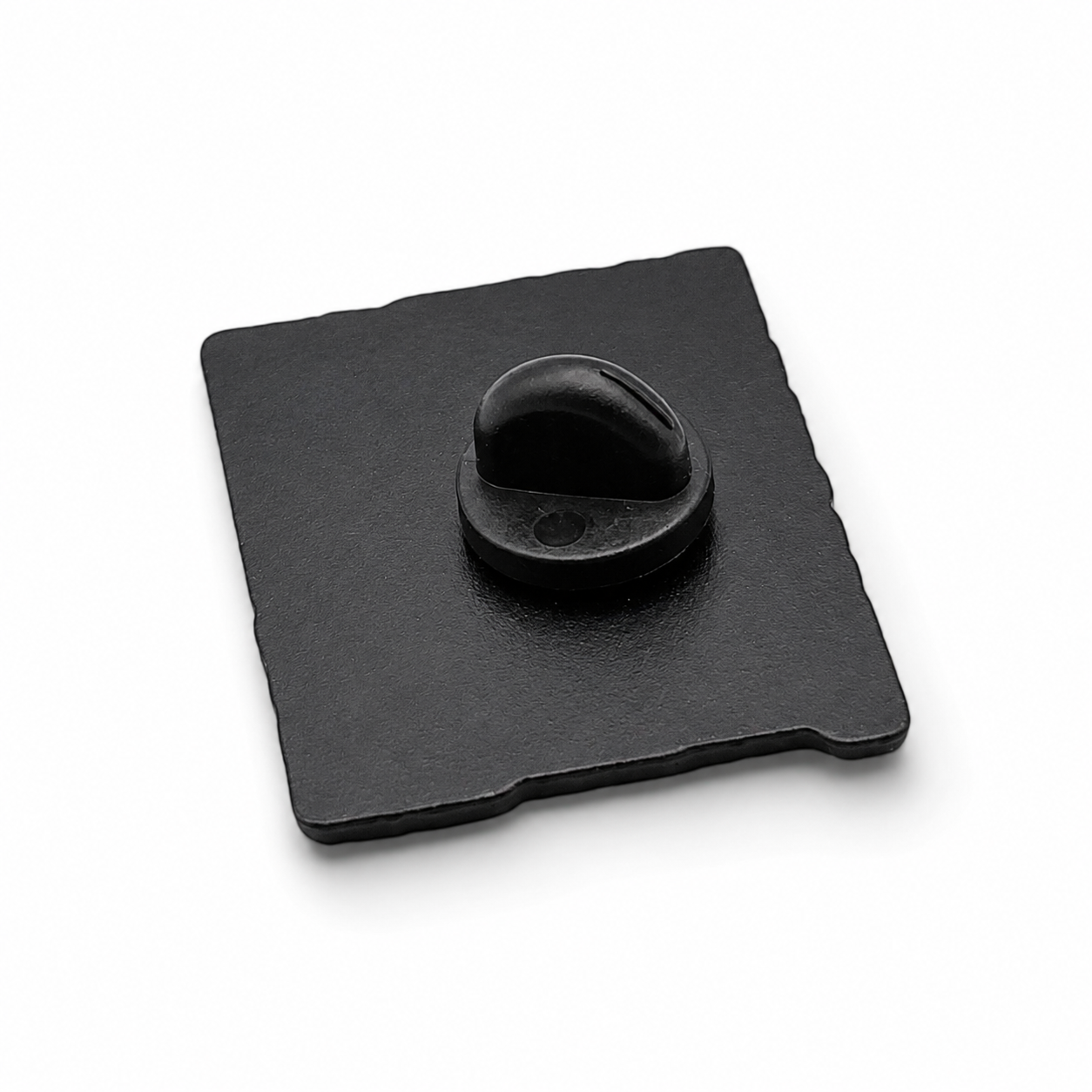 Enamel pin badge back with black rubber clutch and metal pin on dark square backing