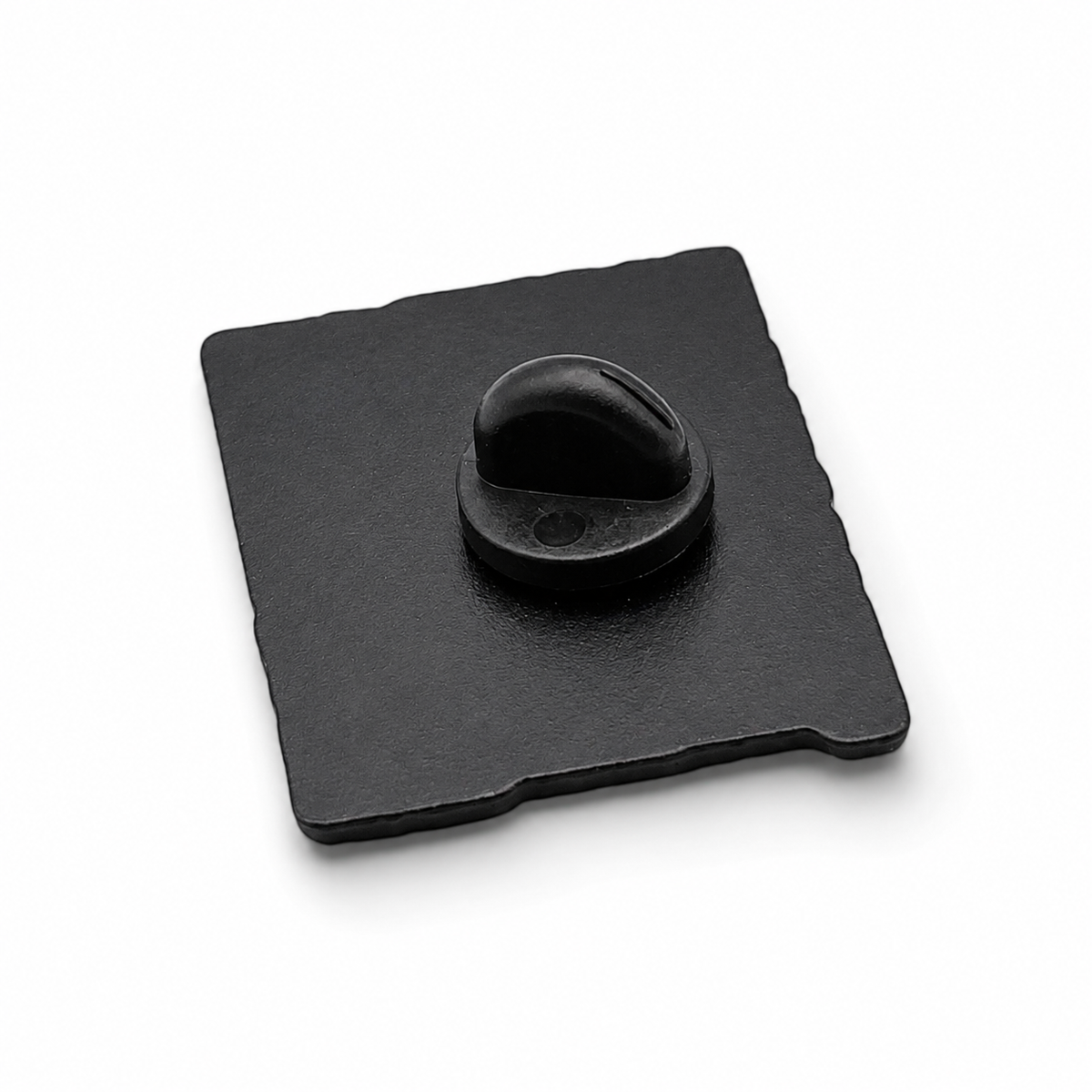 Enamel pin badge back with black rubber clutch and metal pin on dark square backing