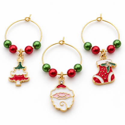 Three wine glass charms with green/red bead rings and festive pendants: tree, snowman, stocking