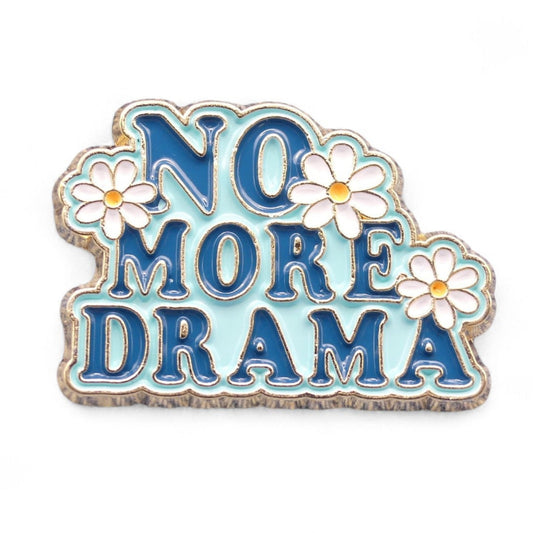 Pale blue enamel pin badge with dark blue text saying no more drama with white daisies. 