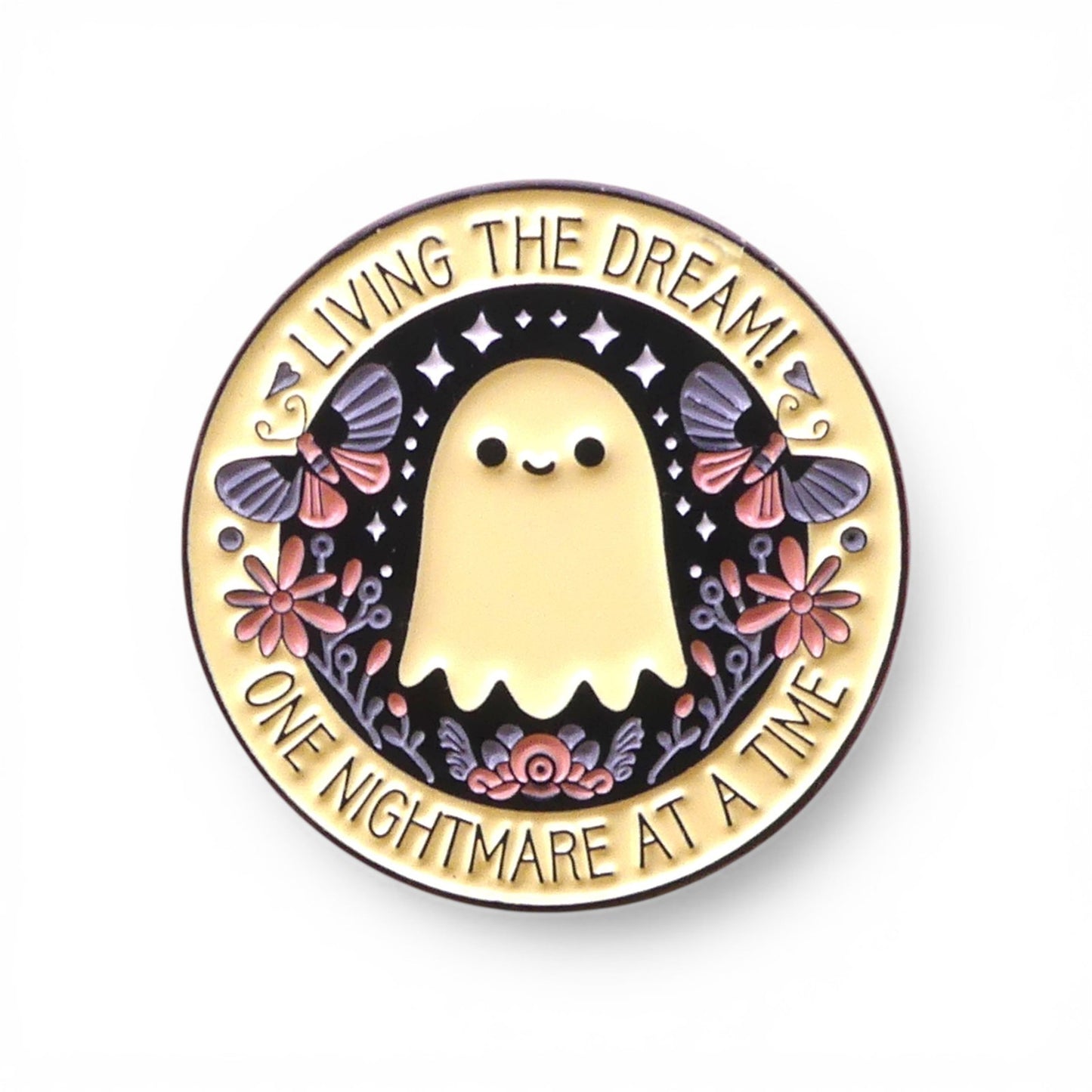 Pin with a ghost design and text 'Living the dream! One nightmare at a time' 