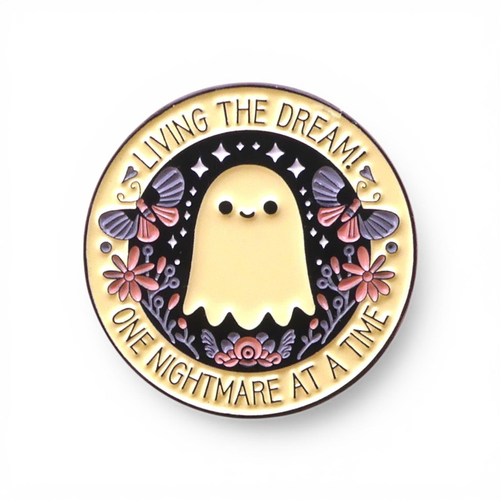 Pin with a ghost design and text 'Living the dream! One nightmare at a time' 