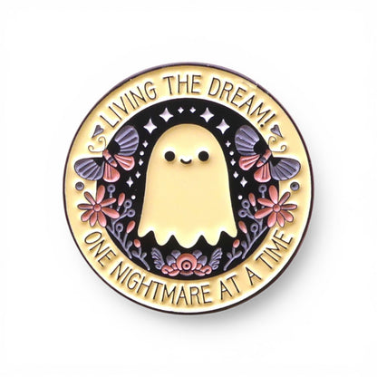 Pin with a ghost design and text 'Living the dream! One nightmare at a time' 