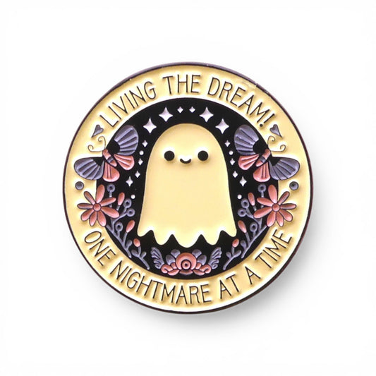 Pin with a ghost design and text 'Living the dream! One nightmare at a time' 