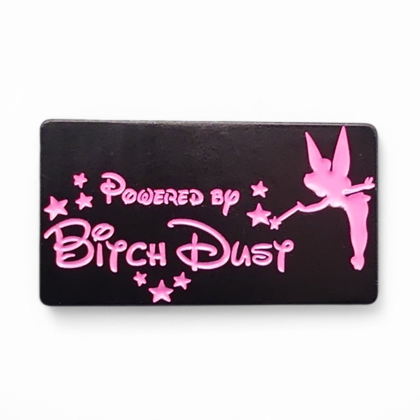 Black Enamel pin badge with pink text saying powered by bitch dust and fairy design