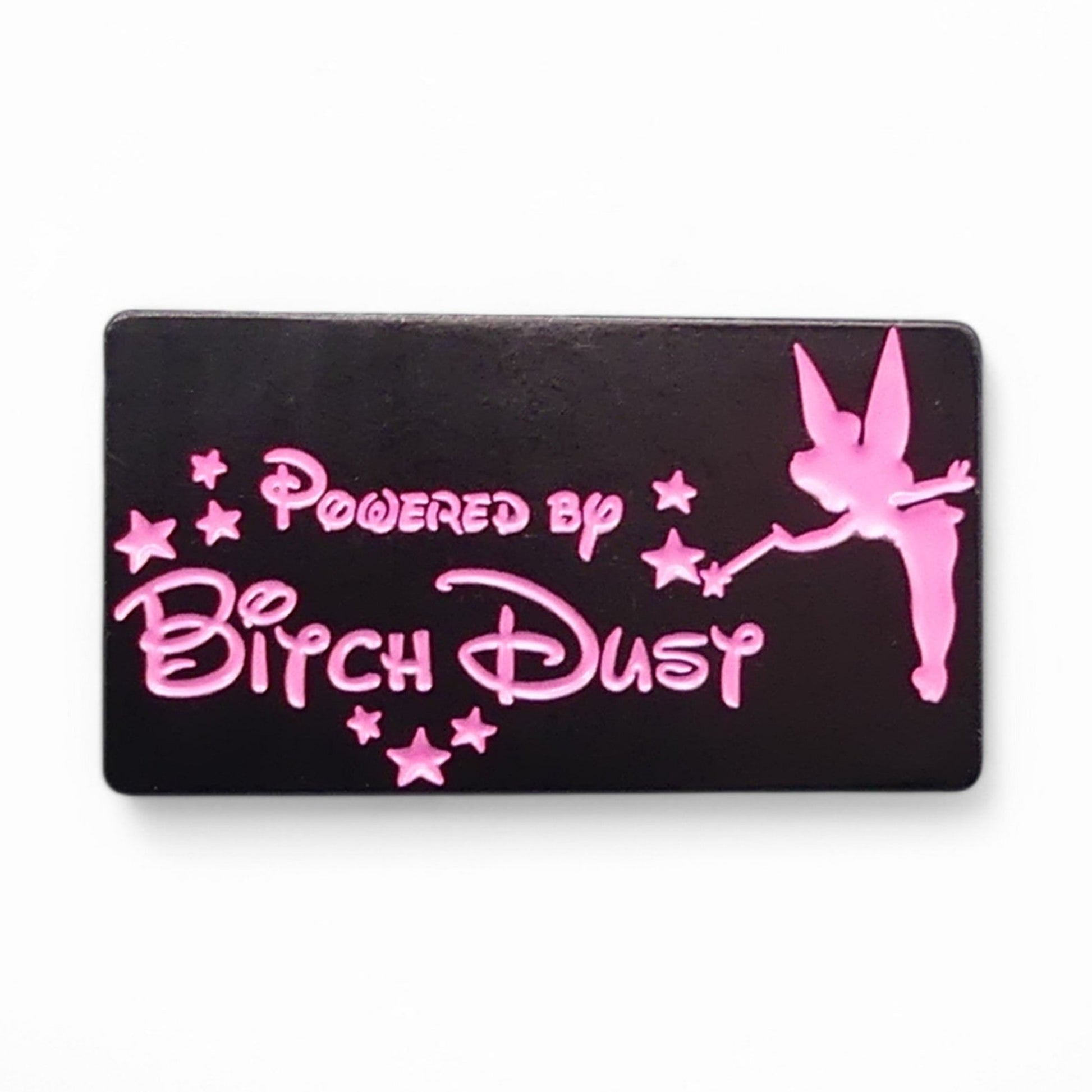 Black Enamel pin badge with pink text saying powered by bitch dust and fairy design