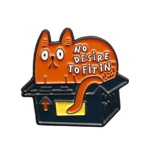 Red cat sitting in a small black box with white text saying No desire to fit in. enamel pin badge.