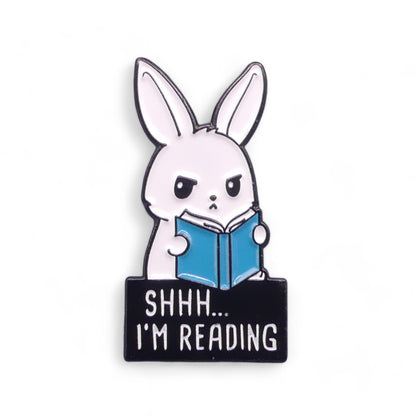 Enamel pin badge of a rabbit reading a book with 'SHHH... I'M READING' text 