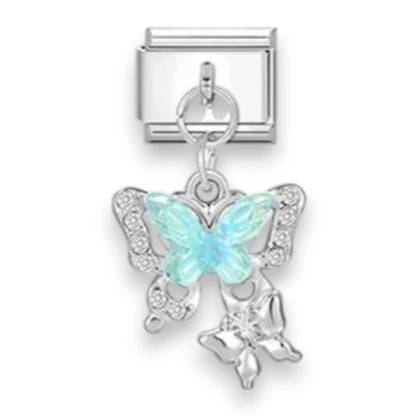 A silver-toned butterfly charm with a light blue iridescent center and small clear rhinestone accents, attached to a silver rectangular connector, shown on a plain white background.