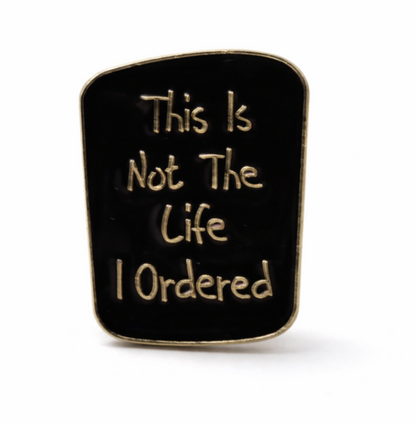 Black square pin with gold text 'This Is Not The Life I Ordered' funny quote