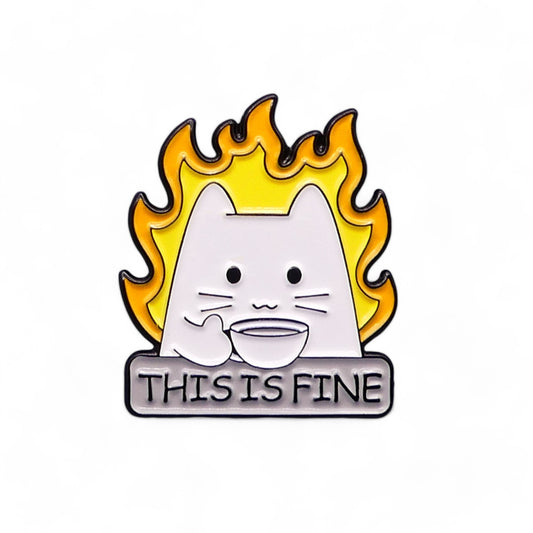 Enamel pin badge with a cartoon cat surrounded by flames and 'This is Fine' text 