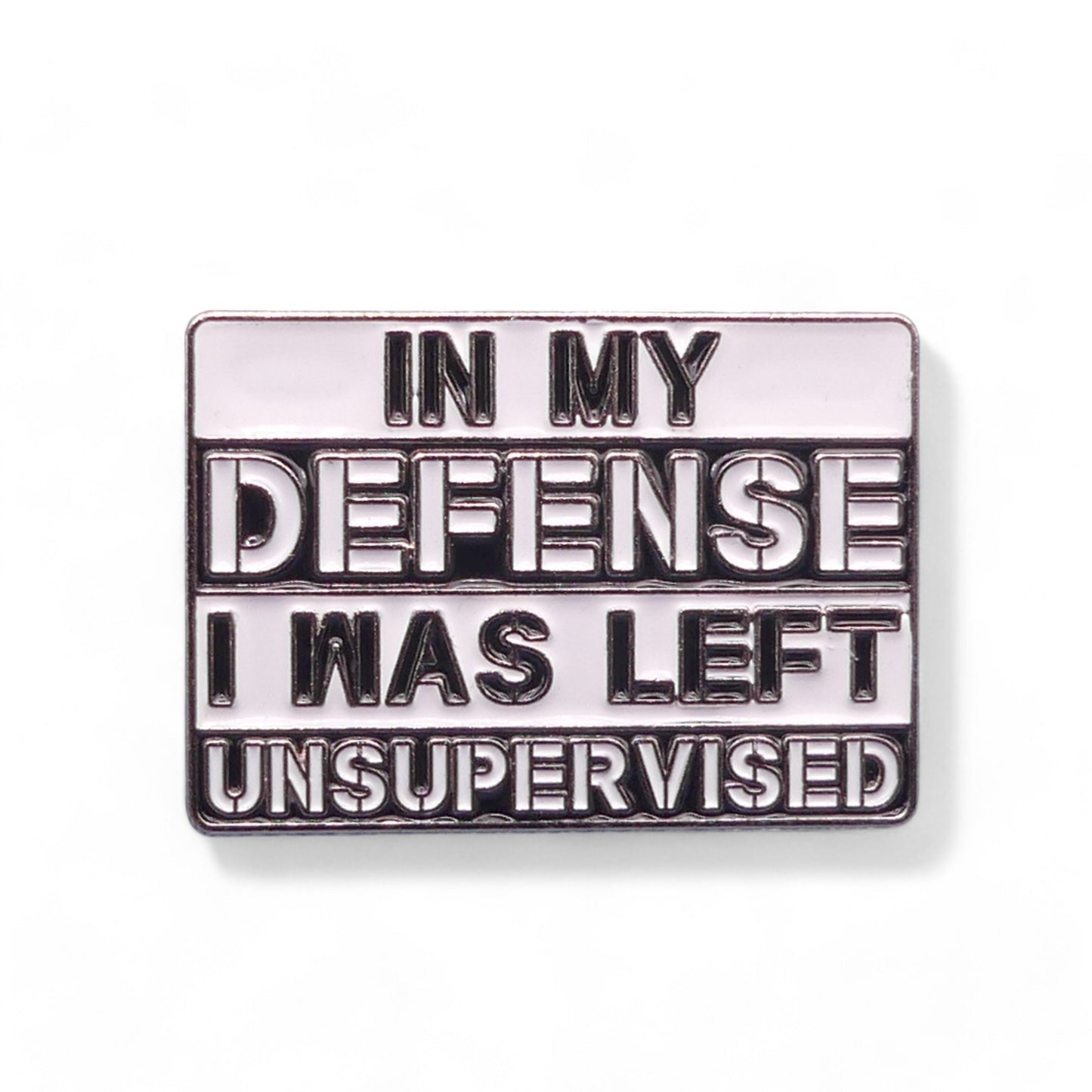 Metallic enamel pin badge with text 'In my defense I was left unsupervised' 