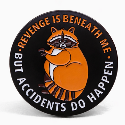 Circular badge with a raccoon illustration and text Revenge Is Beneath Me But Accidents Do Happen